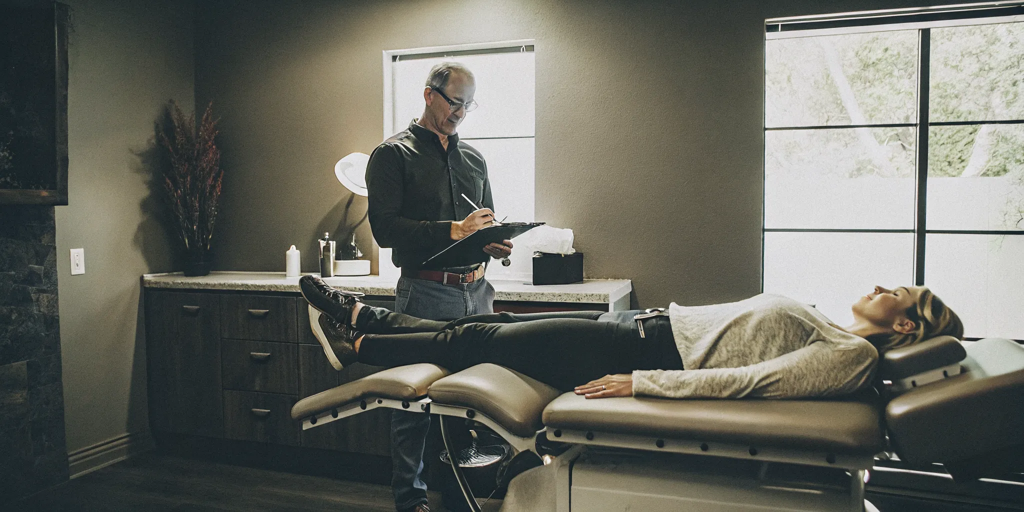 Patient lying relaxed on a DRX9000 spinal decompression table at DRX Chicago while a chiropractor monitors the session